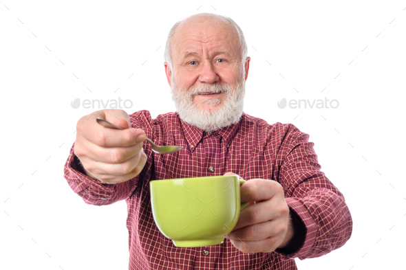 Cheerfull senior man with green cup and teaspoon, isolated on white