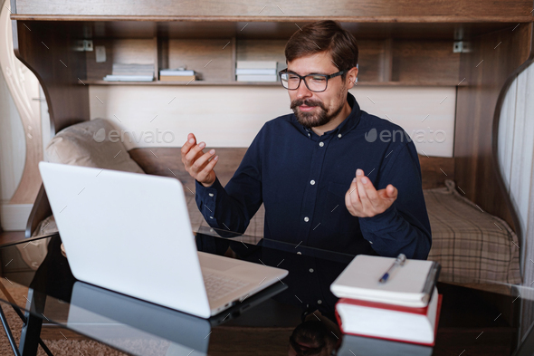 Focused man sitting at desk watching webinar video course