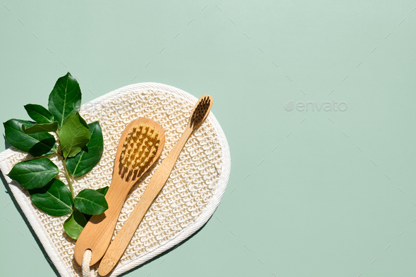 Waste-free bathroom accessories on light green background.