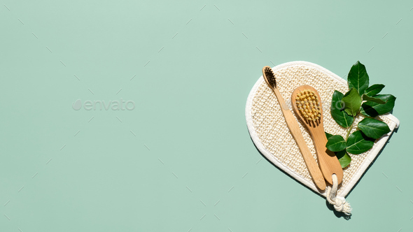 Waste-free bathroom accessories on light green background.