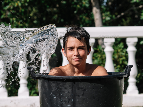 High-speed photograph that captures the impact of water by hitting the face of a teenage boy