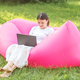 Adult woman working or studying remotely using laptop and internet. Summer. Pink bean bag chair. - PhotoDune Item for Sale