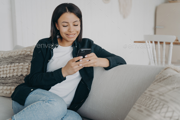 Happy female hold phone chat in social network read good news, shopping via  online store app at home Stock Photo by StudioVK