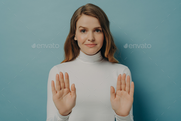 Attractive young focused woman showing stop gesture, saying no ...