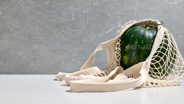 Watermelon in reusable shopping mesh bag.