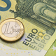 One euro coin on the green hundred bills. - PhotoDune Item for Sale