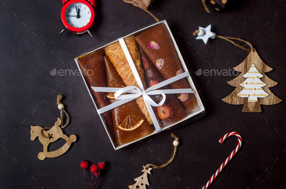 Christmas gift box with dry fruits and decorations on dark