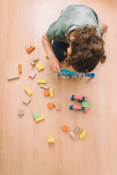 girl playing with building blocks in the floor