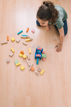 girl making constructions with wooden blocks