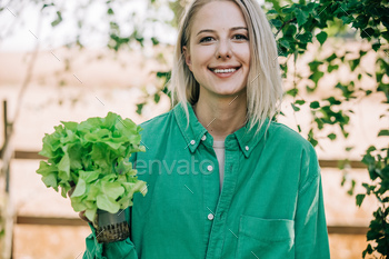 Stylish woman in green shirt hold lettuce in outdoor