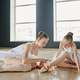 Young ballet teacher in white tutu helping youthful girl with pointe shoes - PhotoDune Item for Sale