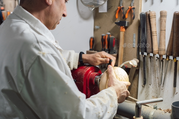 Cabinetmaker placing piece of wood on lathe