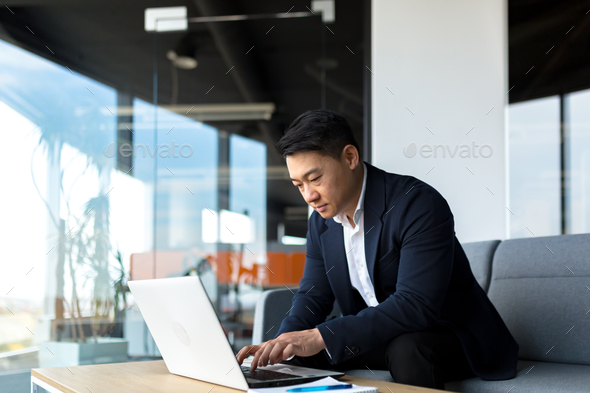 balanced and calm businessman, asian man thinking working at laptop sitting in the office
