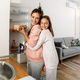 White mother and daughter smiling and hugging in kitchen - PhotoDune Item for Sale