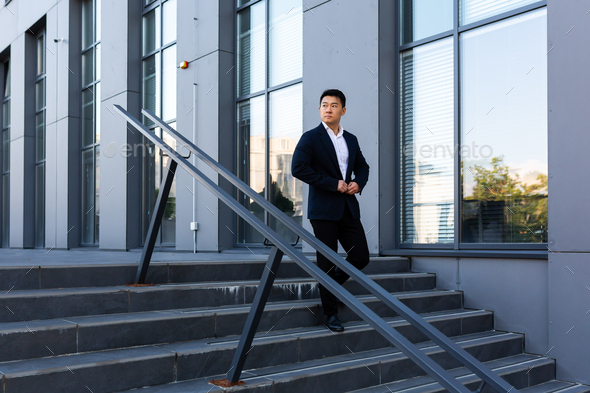 Asian businessman walks up the stairs of the office center, man hurries to a business