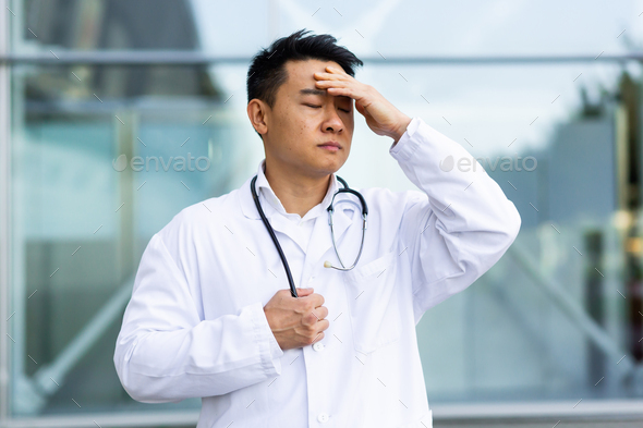 Asian doctor is tired after work, depressed and disappointed with the work done on the street