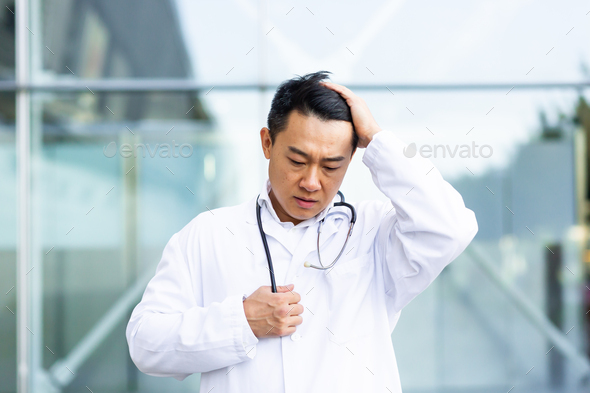 Asian doctor is tired after work, depressed and disappointed with the work done on the street
