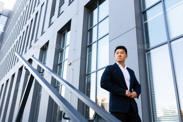 Asian businessman walks up the stairs of the office center, man hurries to a business