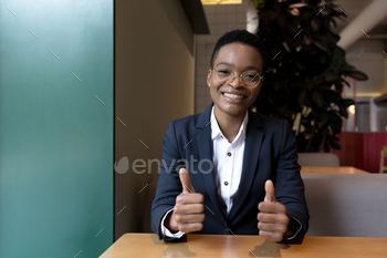 view from the camera, african american business woman looks at the camera and smiles