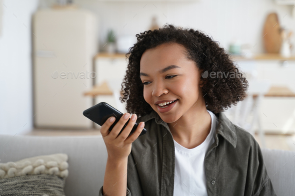 Friendly african american young girl hold smartphone leave voice message or use virtual assistant