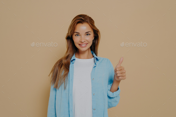 Happy young caucasian female in blue shirt with long sleeves