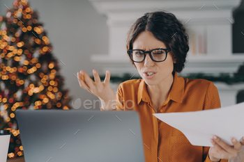Stressed Italian businesswoman feels angry with error or mistake while remotely working on Christmas