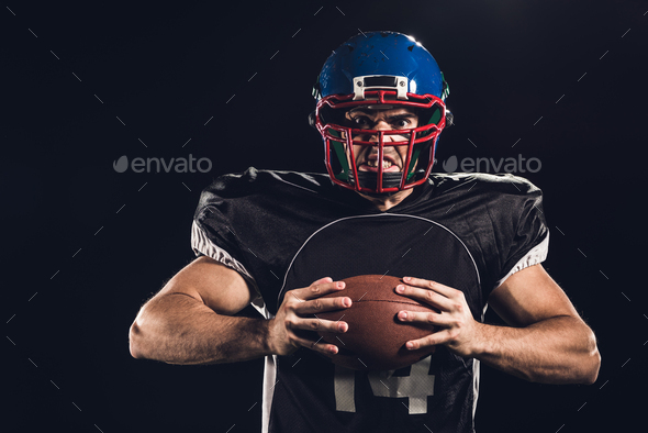 Football Player Holding Football With Both Hands Stock Photo