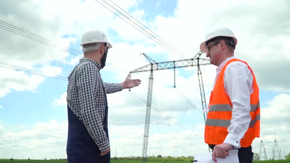 Two Engineers Working Near Transmission Lines alt