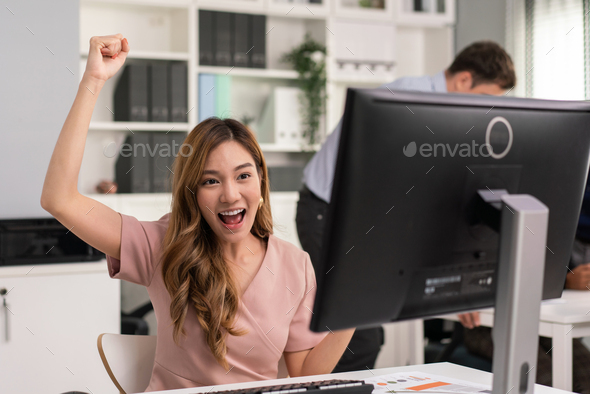 Female employee raising hands happy and laugh for receiving good news