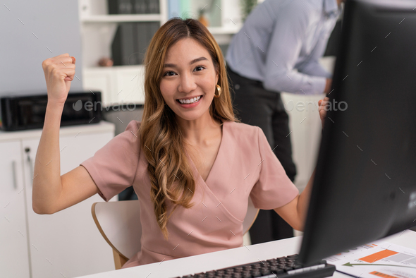 Female employee raising hands happy and laugh for receiving good news