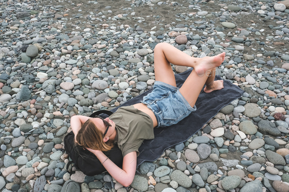 Travel.Traveler girl resting on the beach near the sea. Eco travel, taking care of yourself physical