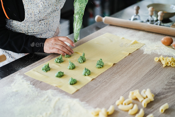 Woman prepare fresh made ravioli inside pasta factory