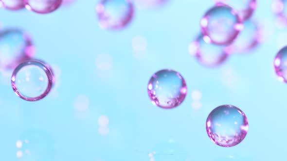 Super Slow Motion Shot of Neon Hydrogel Balls Bouncing on Glass at 1000Fps alt