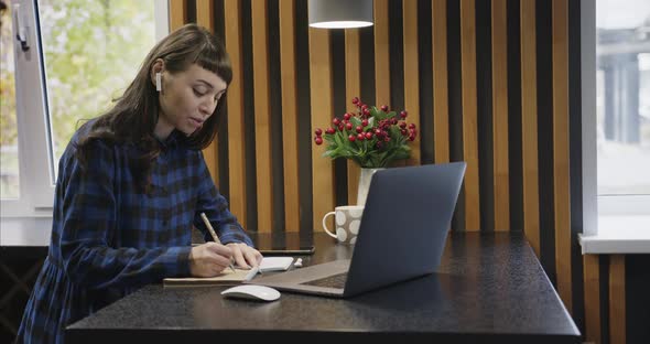 Portrait of a Young Girl in Headphones Talking in Front of a Laptop Screen