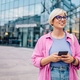 Young plus size woman using smartphone while walking in the city. - PhotoDune Item for Sale