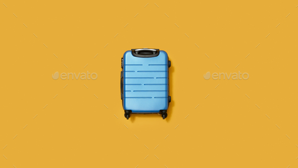 Flat Lay Shot Of Blue Holiday Suitcase On Yellow Background - Stock Photo - Images
