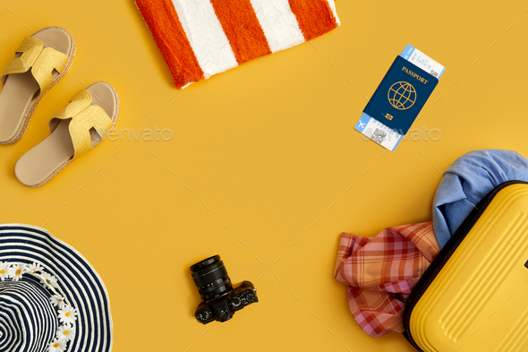 Flat Lay Shot Of Yellow Suitcase Unpacked With Holiday Accessories On Yellow Background - Stock Photo - Images