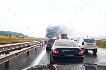 Car crash accident on a highway with damaged automobiles and smoke