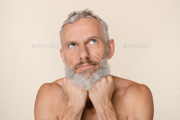 Pensive thoughtful caucasian middle-aged man with bare shoulders naked