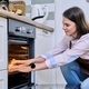 Young woman cooking food in the oven at home in the kitchen. - PhotoDune Item for Sale