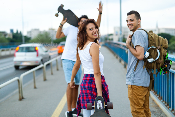 Group of happy teen people hang out together and enjoying skateboard outdoors - Stock Photo - Images