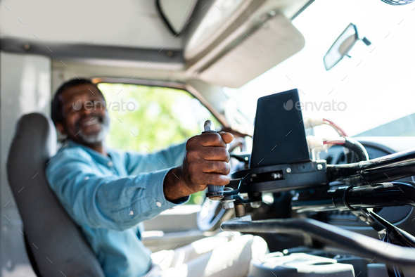 mature african american bus driver pulling lever at bus