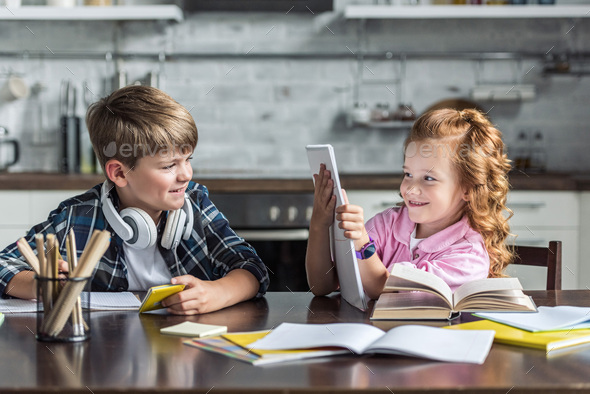 playful little kids doing homework together at kitchen Stock Photo by ...