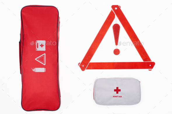 flat lay with automotive handbag, first aid kit and warning triangle isolated on white