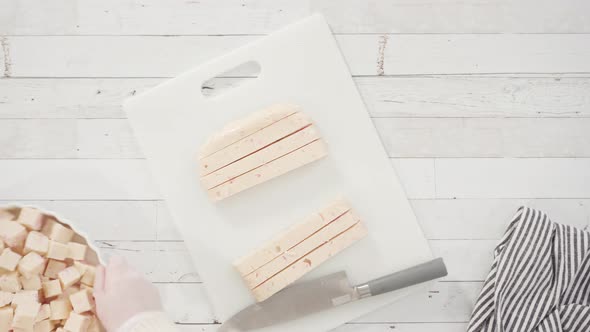 Flat lay. Step by step. Cutting homemade candy cane fudge on a white cutting board. alt