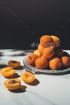 food composition with fresh apricots on metal tray with black background