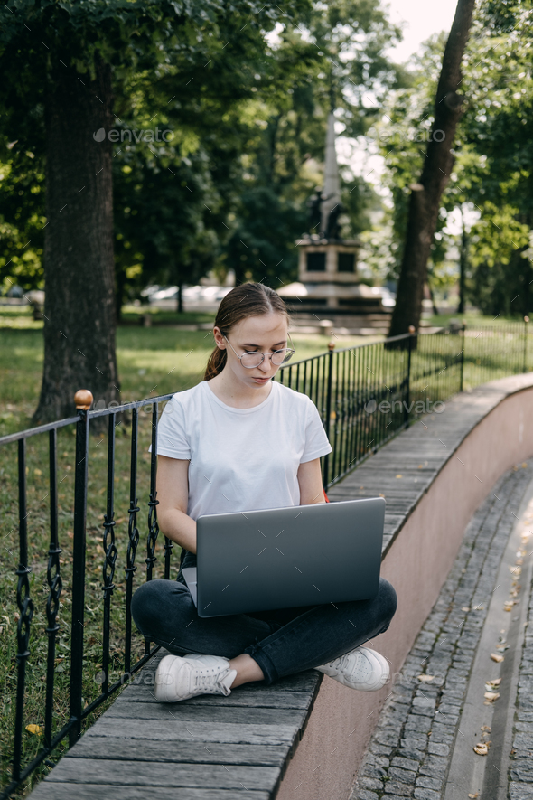 Online jobs for college students. Young woman student girl searching job with laptop outdoors