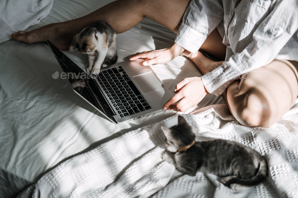 Work From Home Jobs, remote online work, home office. Woman working on laptop in bed