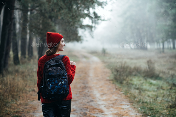 Weekend breaks and getaways in forests. Stay close to nature. Young woman in red hat