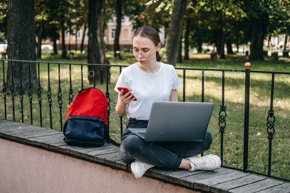 Online jobs for college students. Young woman student girl searching job with laptop outdoors